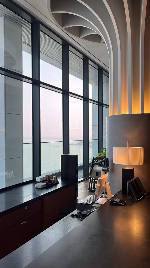 Elegant bar counter area with oceanfront floor-to-ceiling windows at McQueen's Lounge