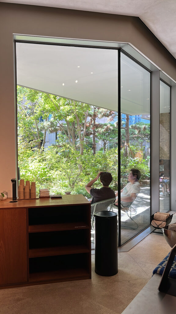 Outdoor terrace lounge area connecting indoor and garden views at Momos Coffee Marine City