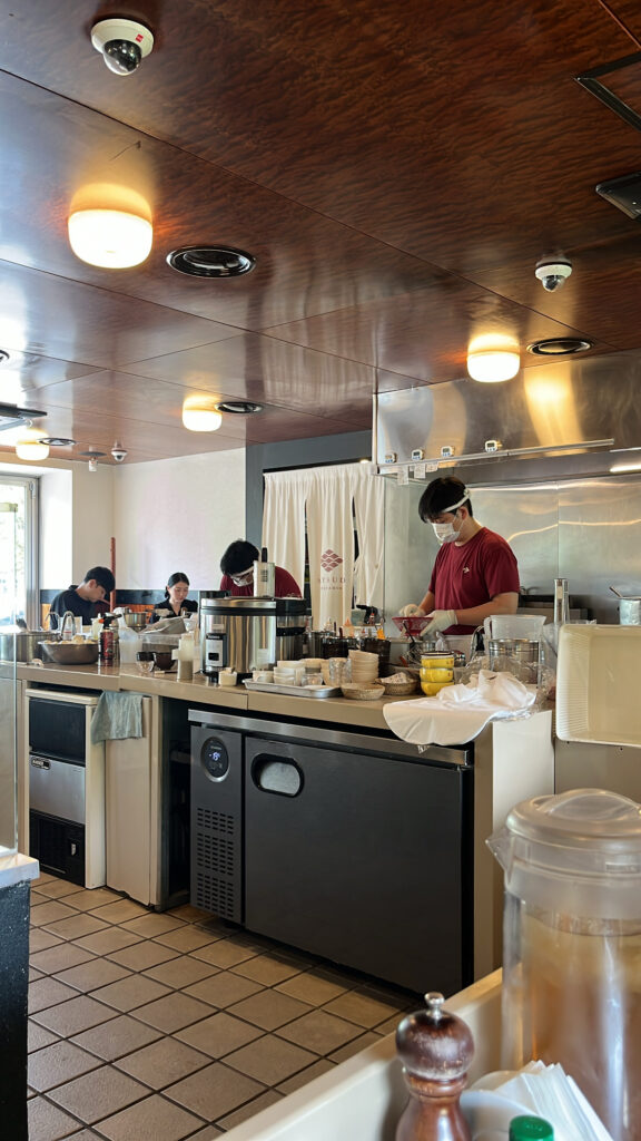 Open kitchen counter view where staff prepare complimentary rice at Matsudo Busan