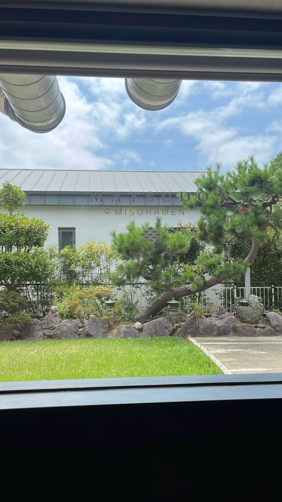 Green garden and outdoor walking path outside the Matsudo Busan building in Gijang