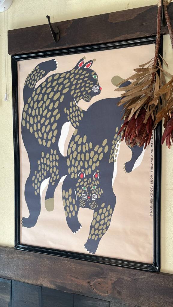 Cute framed artwork of two cats hanging on the interior wall at Pili Pili Busan