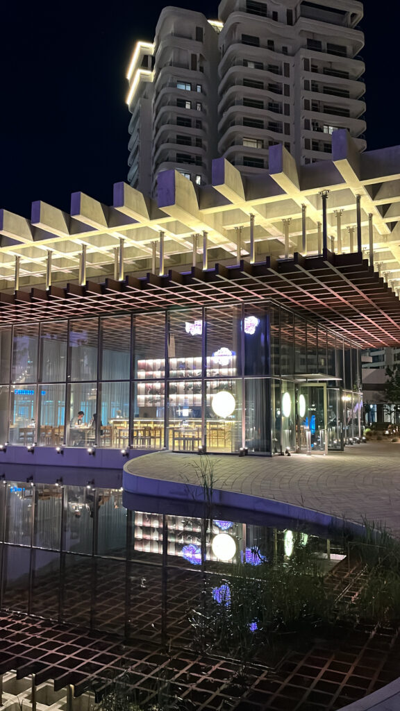 Atmospheric evening night view of Sobae Busan reflected over the calm outdoor pool