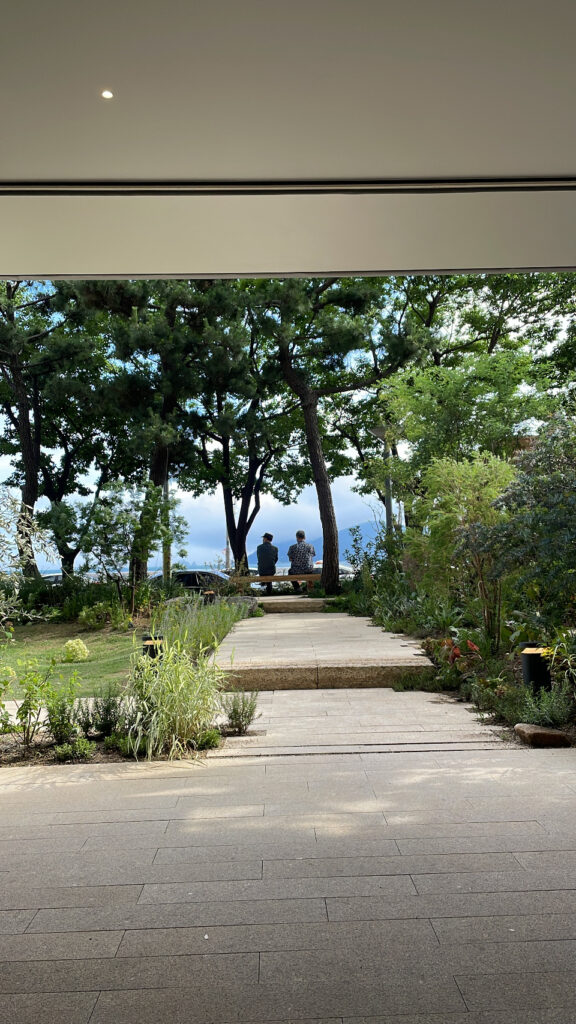 Well-grown greenery and stone garden pathway outside Momos Coffee Marine City