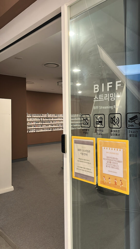 Glass door entrance leading into the free multimedia video screening room at the library