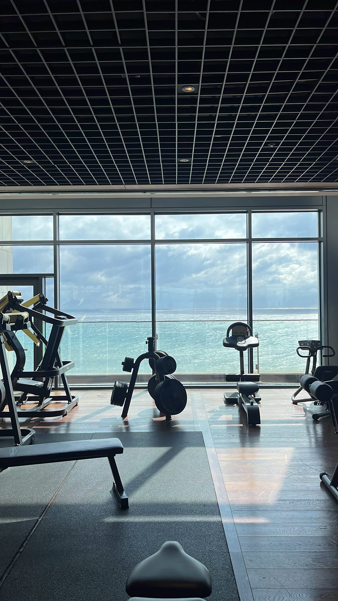 Gimnasio situado en la 9.ª planta, equipado con máquinas de cardio y con vistas panorámicas al mar