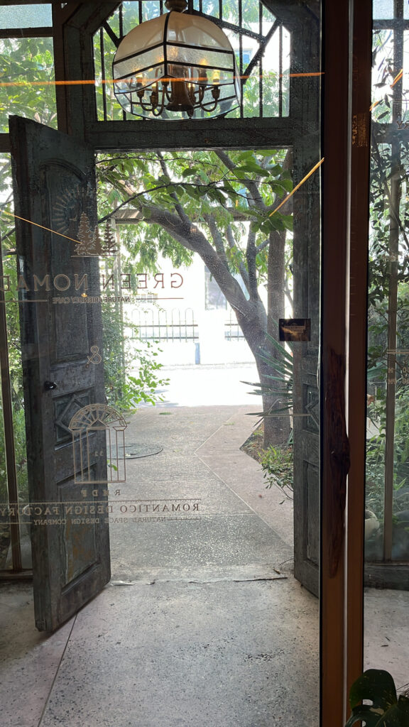 Garden exit gate with greenery and sunlight view at Green Nomad Busan near Suyeong River