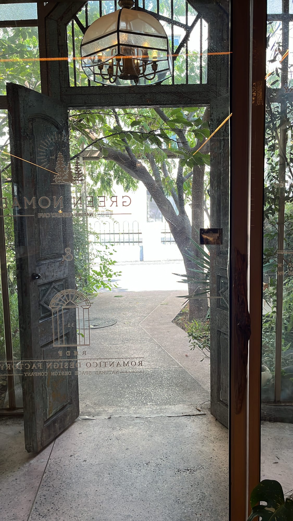 Garden exit gate with greenery and sunlight view at Green Nomad Busan near Suyeong River