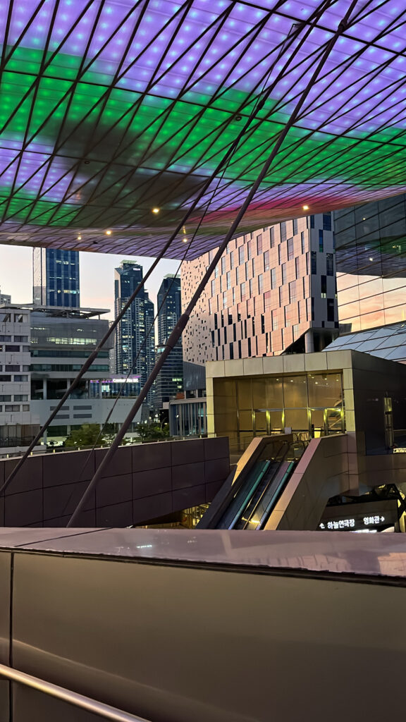 Giant LED roof glowing with vivid colorful lights during evening twilight