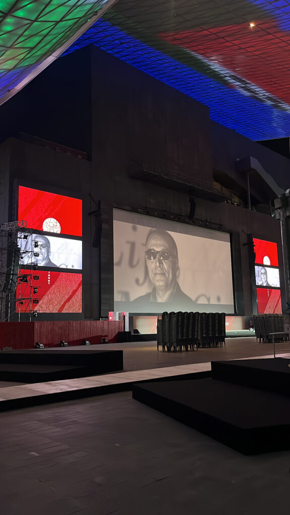 Giant outdoor theater screen and seating plaza at Busan Cinema Center by night