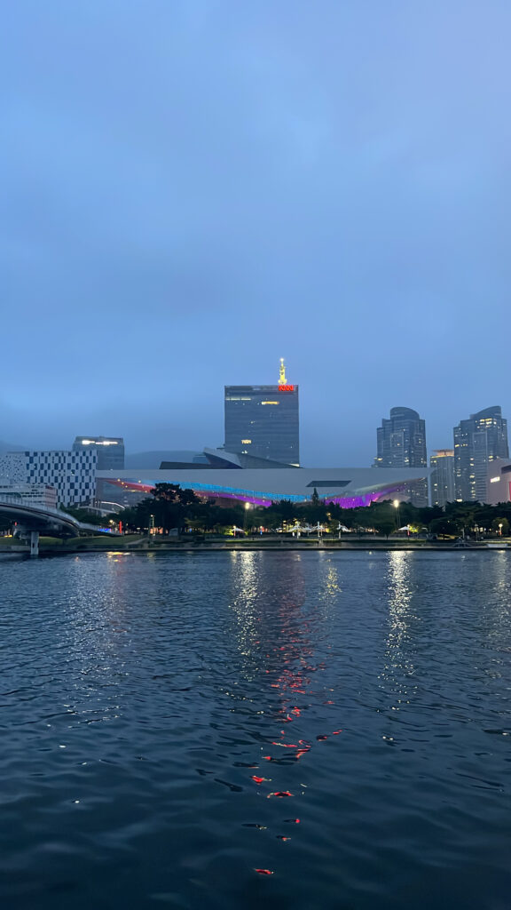 Beautiful night reflection of Busan Cinema Center along the Suyeong River walkway