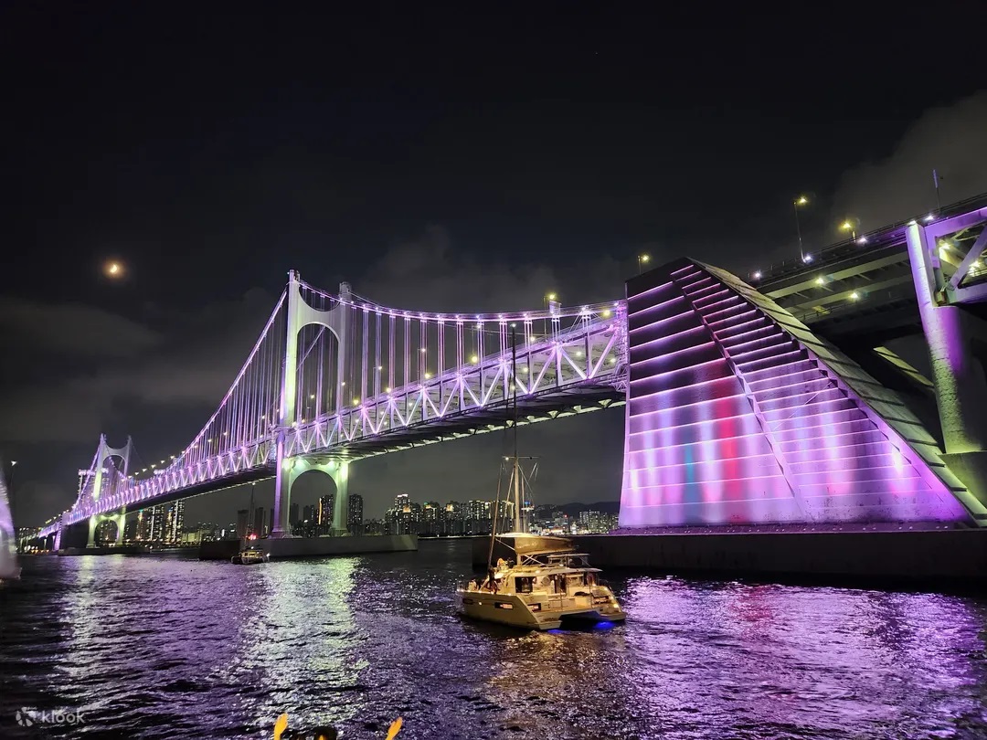 Night yacht tour sailing past illuminated Gwangan Bridge in Busan