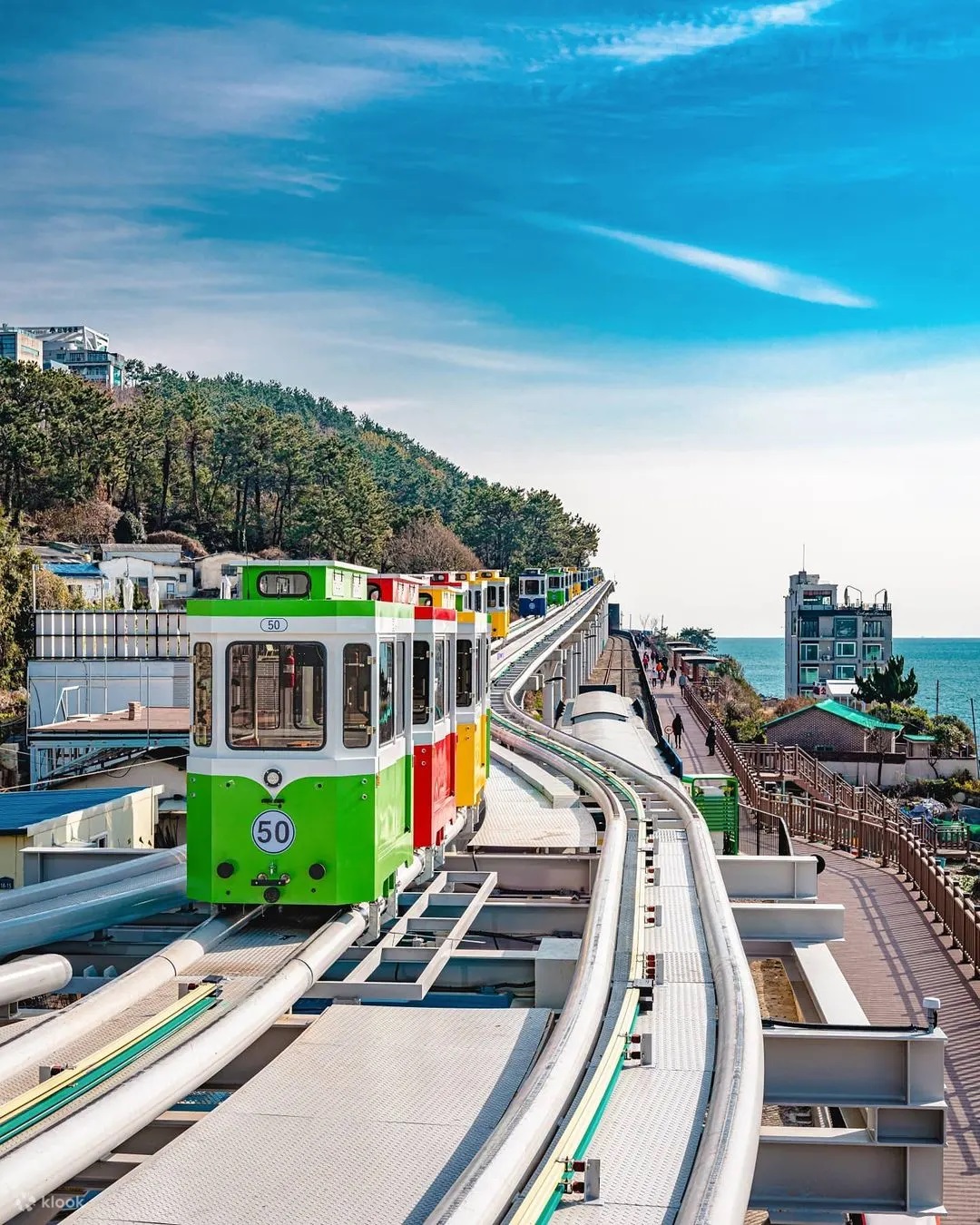 Colorful Haeundae Blueline Park Sky Capsule running along coastal track in Busan