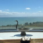 Silver bird sculpture placed on the windowsill overlooking the ocean at Bibibidang Busan