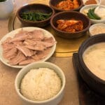 釜山の「ゲデ・ドウェジ・グクバプ」で、茹で豚肉とスープがセットになった本格的な韓国風食卓