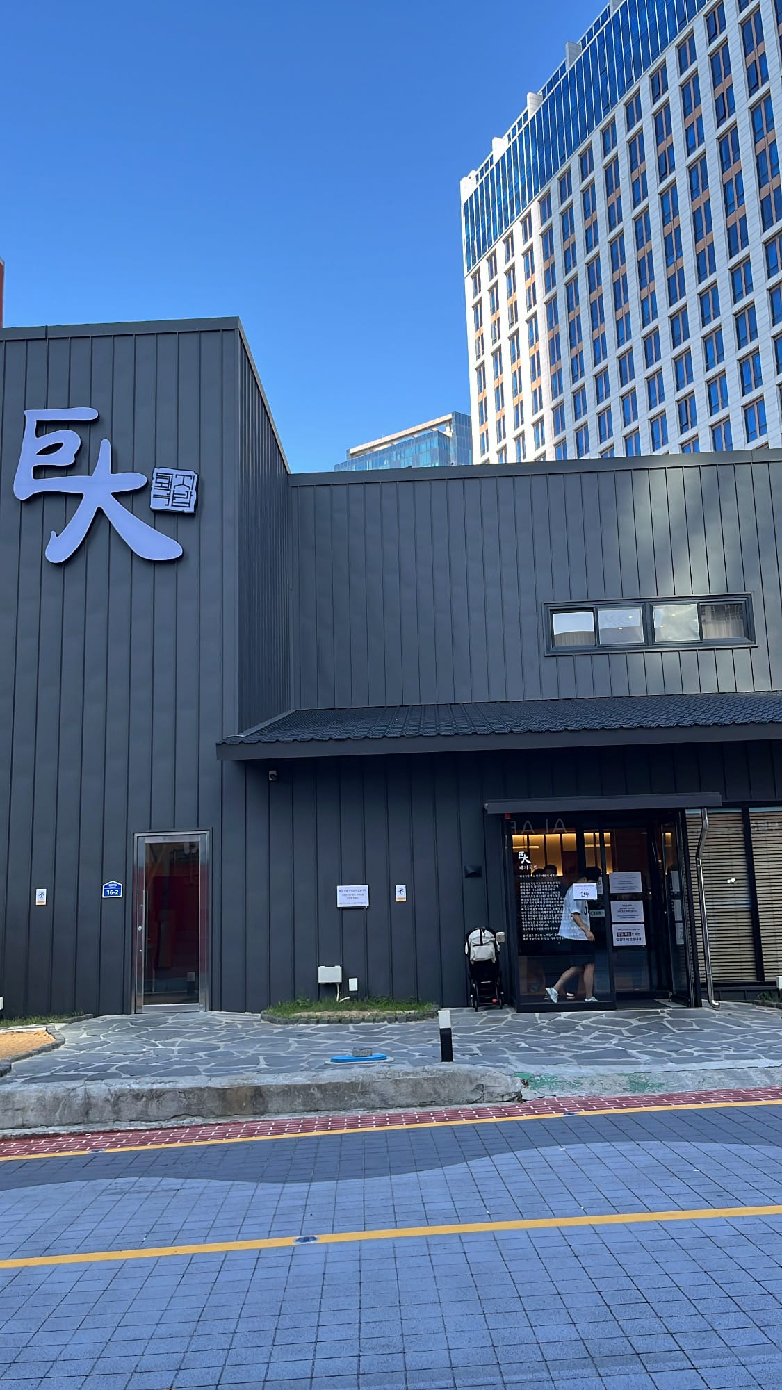 Modern dark charcoal building facade and logo sign of Geodae Dwaeji Gukbap Busan