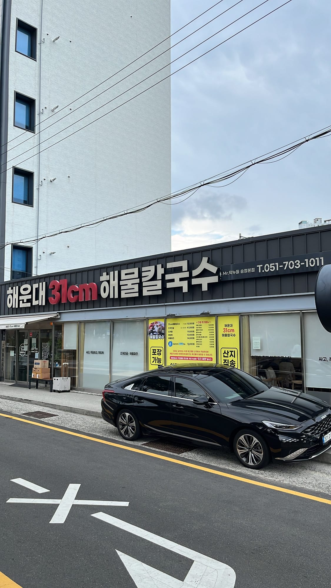 Full building facade and outdoor parking area at Haeundae 31cm Seafood Kalguksu