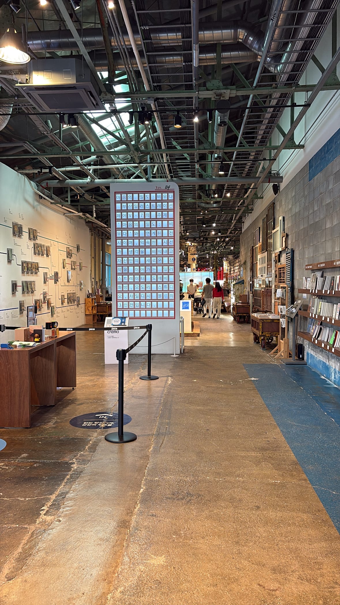 Expansive industrial interior hallway with book displays at YES24 Busan