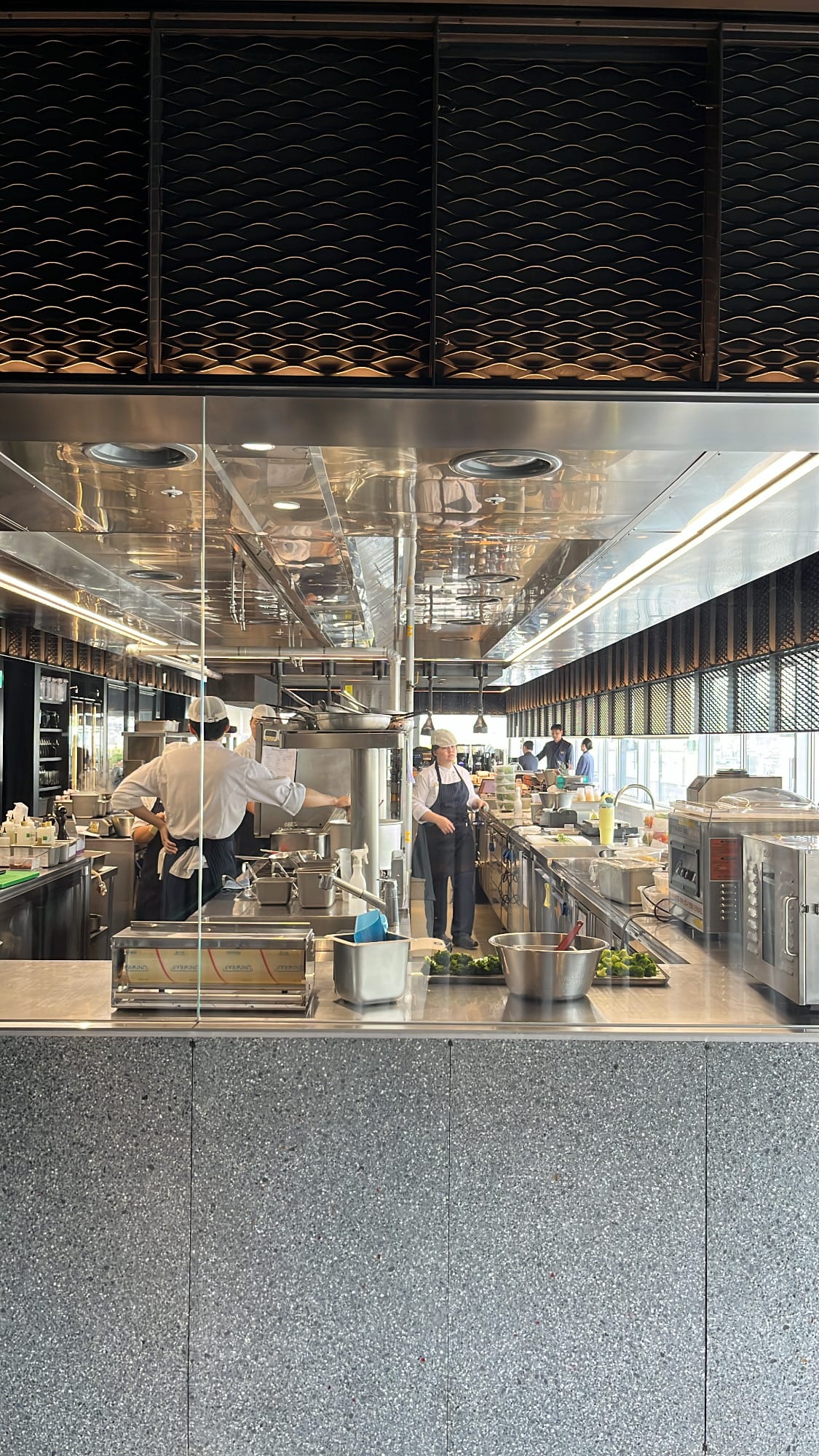 Professional chefs working inside the spotless open kitchen at Michael's Urban Farm Table