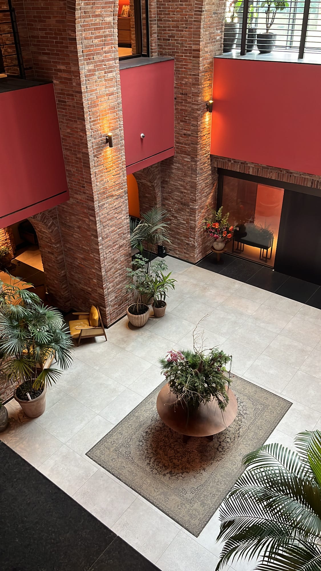 Overhead view of the spacious high-ceiling brick atrium lounge near Village de Ananti Lou Busan