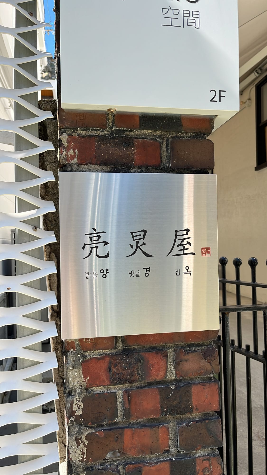 Yangkyungoak Busan modern brushed metal nameplate on brick pillar