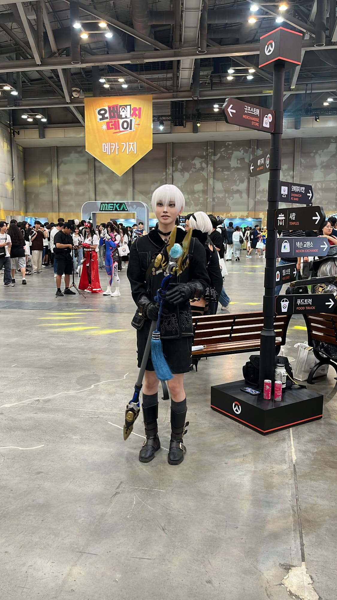 Cosplayer holding a glowing staff inside BEXCO event hall