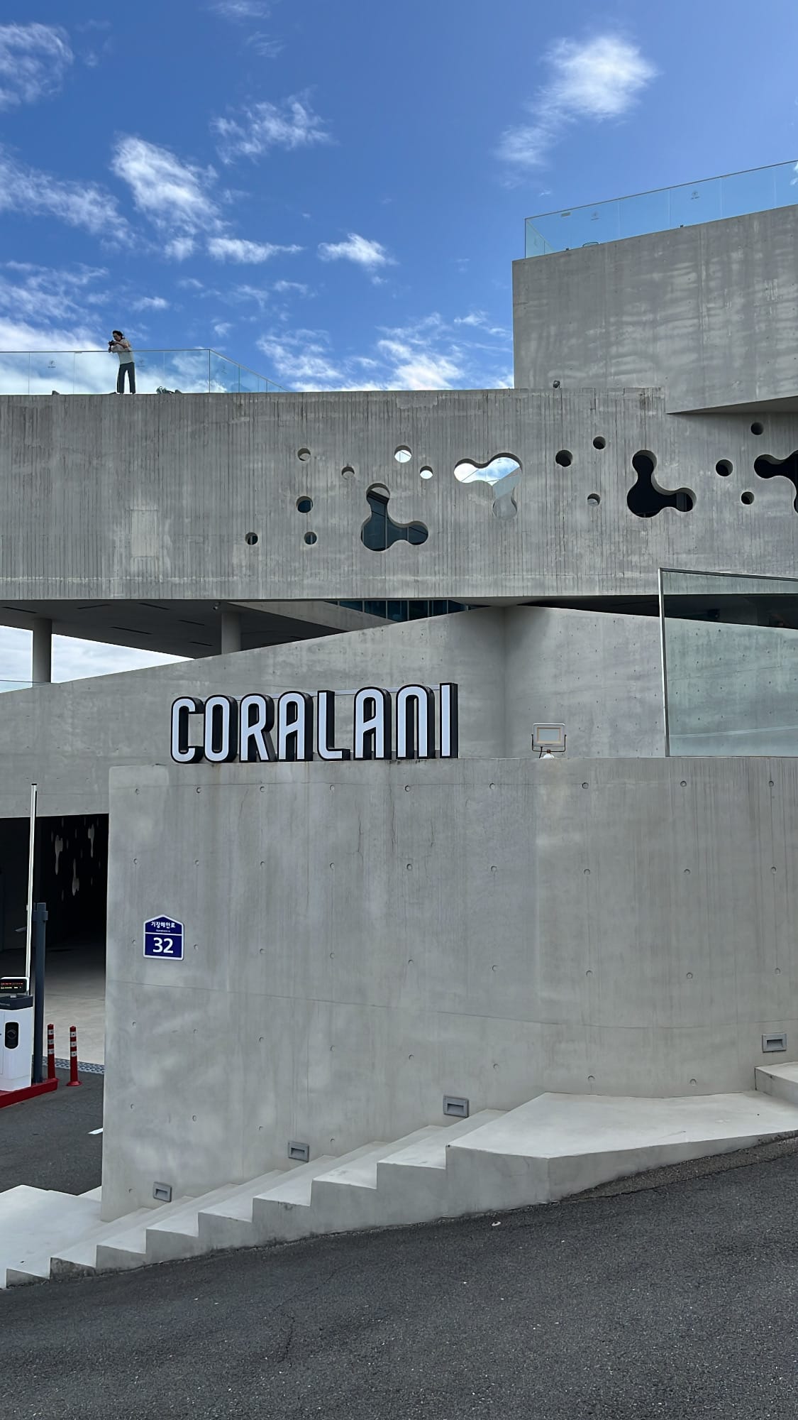 Minimalist exterior wall and Coralani Busan logo signage at the entrance