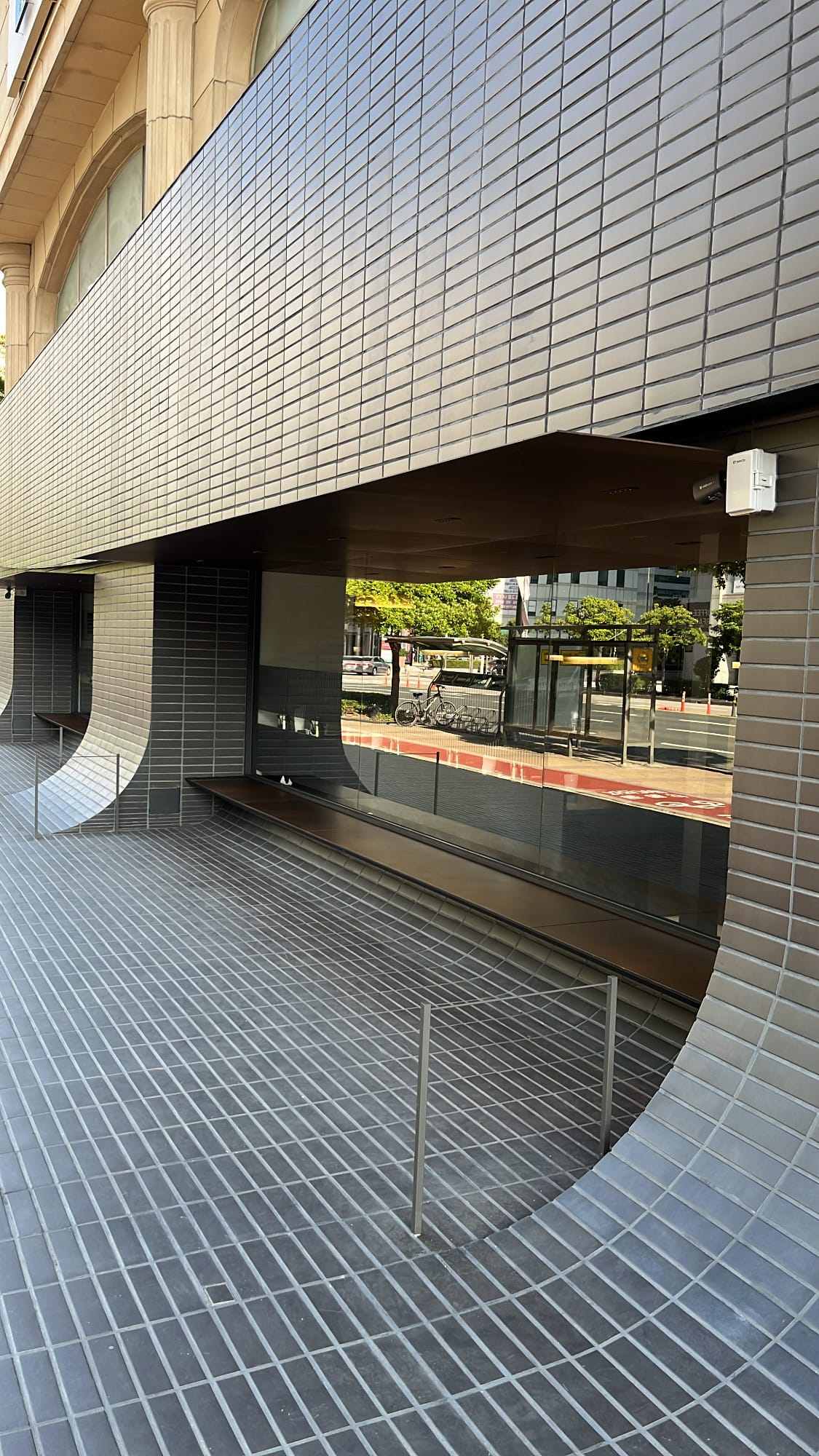Curved tile waiting bench integrated into the exterior wall of Geodae Gomtang Busan
