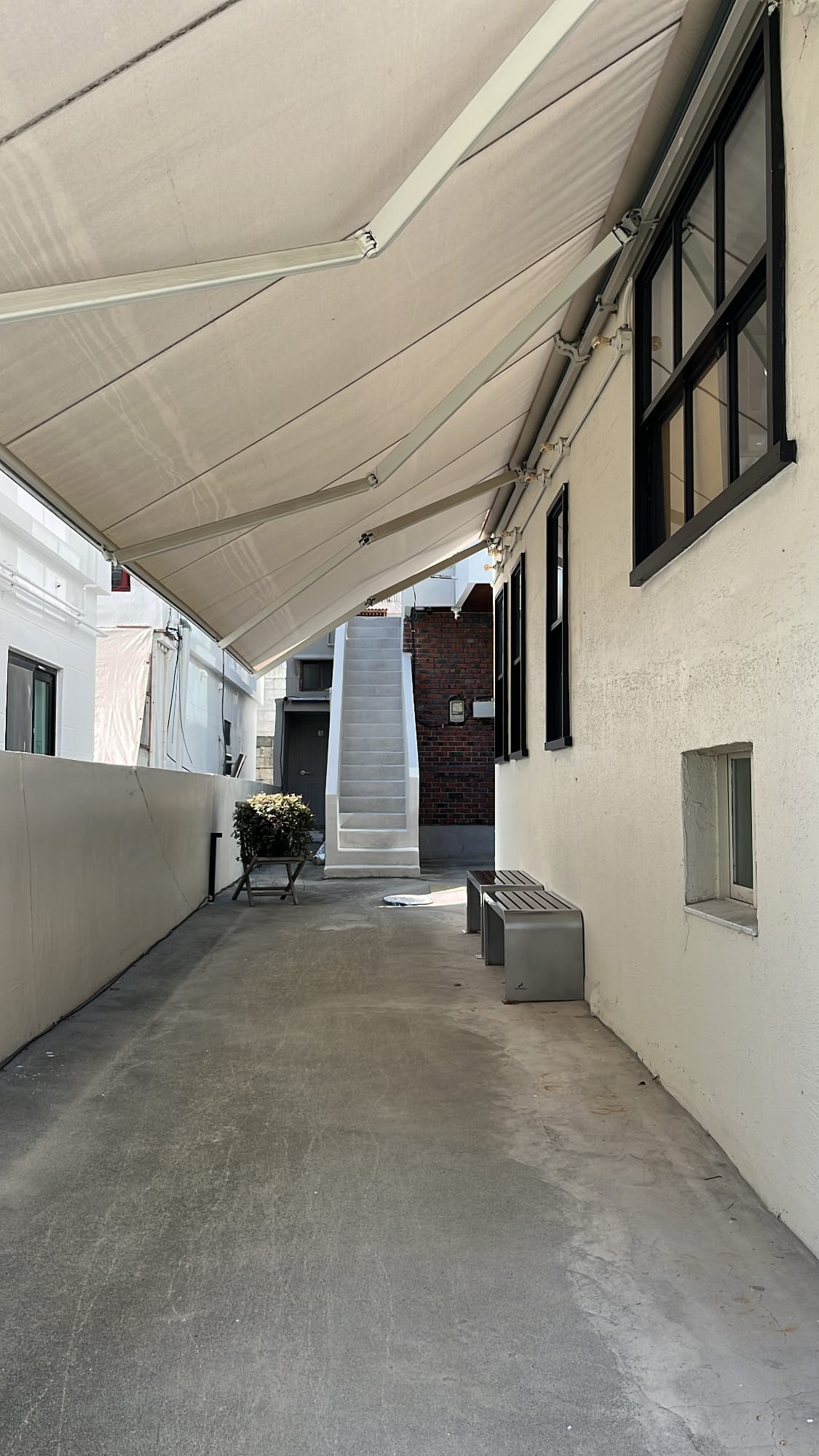 Exterior white alleyway walkway with awning leading to Yangkyungoak Busan