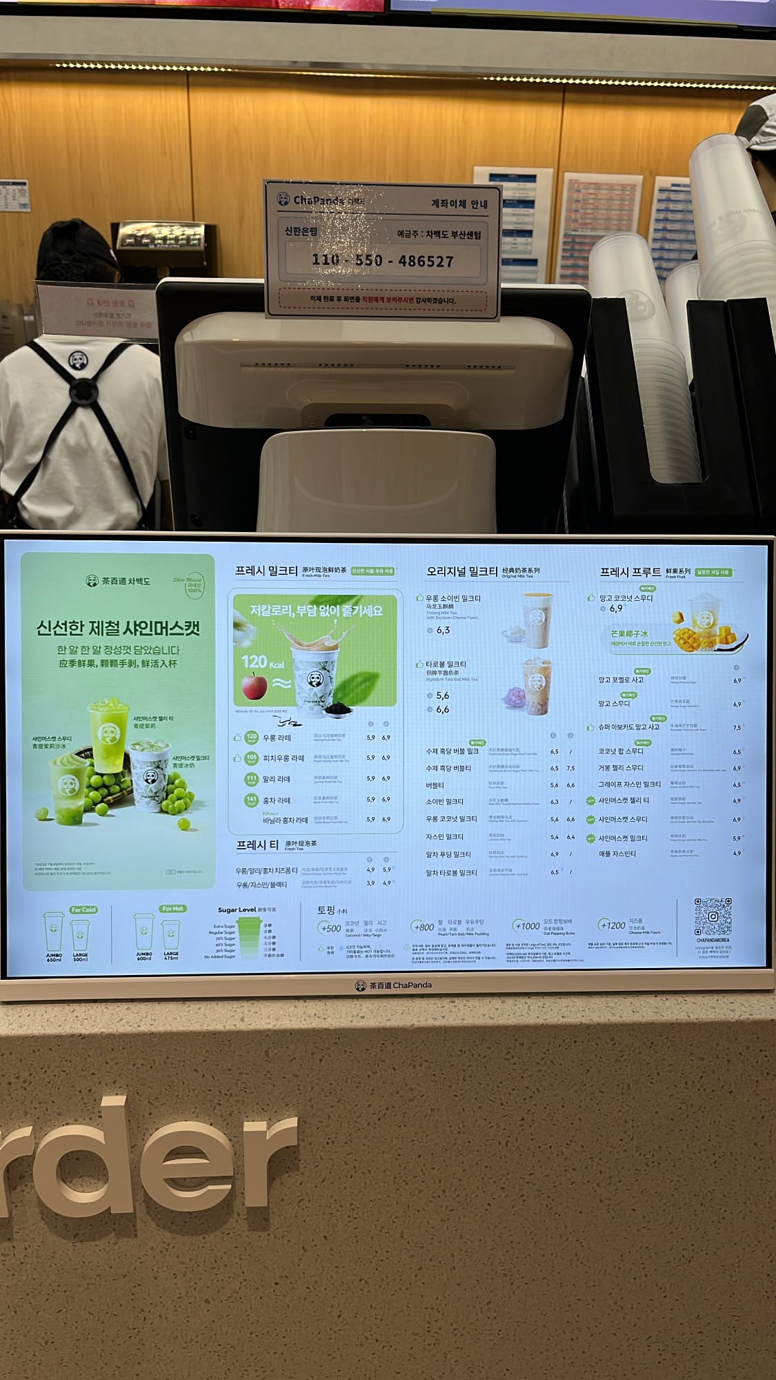 Detailed digital menu screen on counter showing seasonal shine muscat and milk tea options at ChaPanda Busan Centum