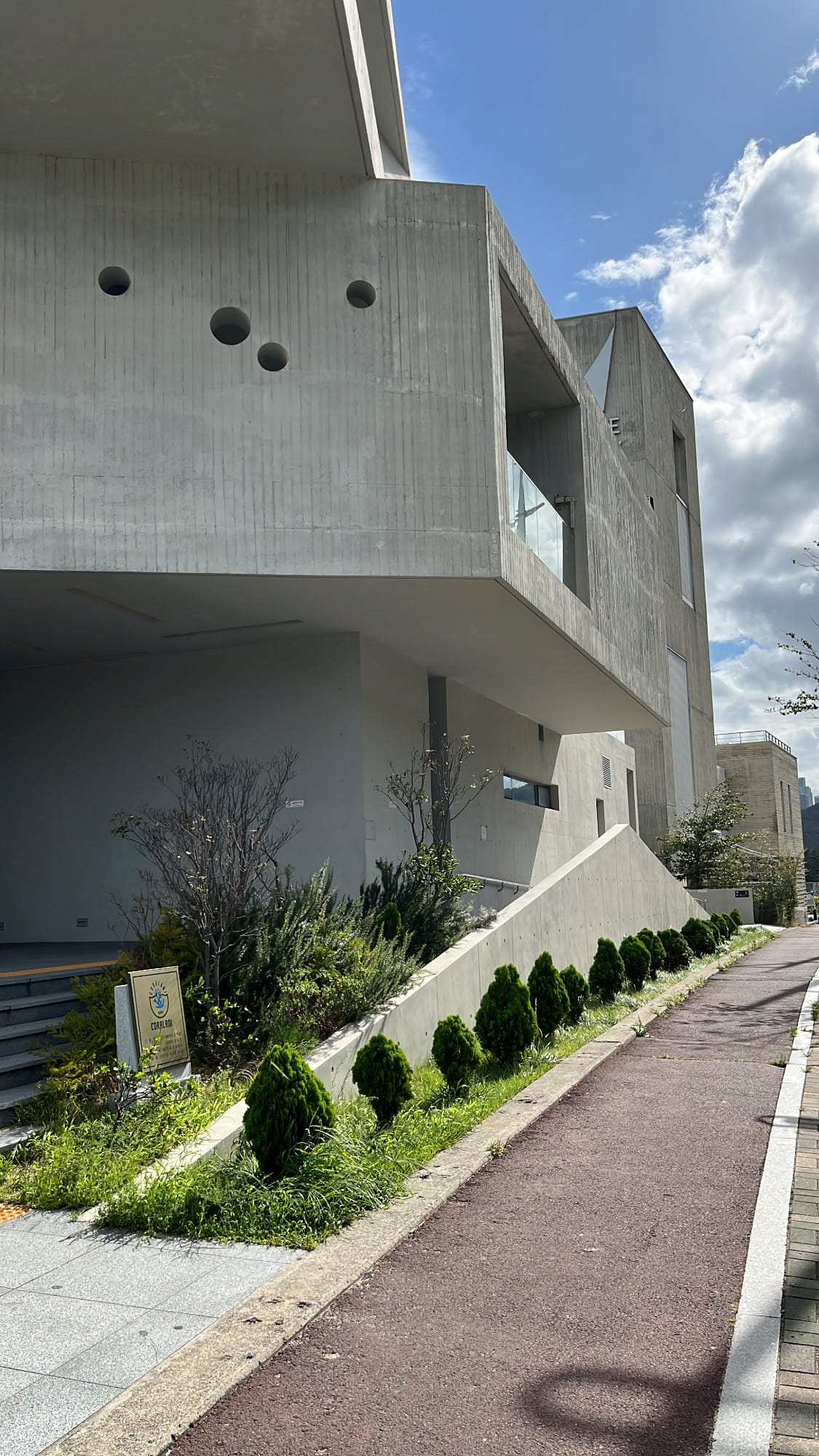 Landscaped pedestrian walkway leading to the main entrance of Coralani Busan