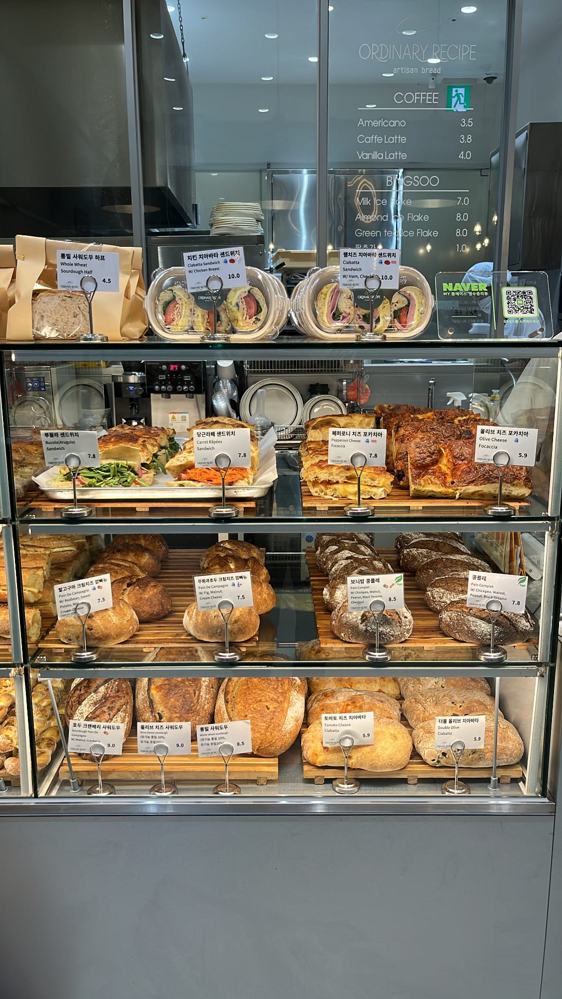 Artisanal whole wheat loaves, focaccia slices, and packaged sandwich rolls at Ordinary Recipe Centum