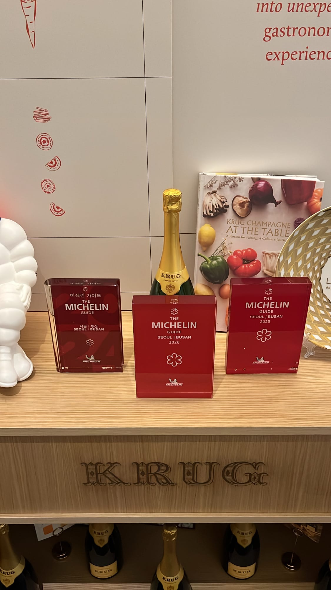 Official Michelin plaques and Krug Champagne bottle at Palate Busan