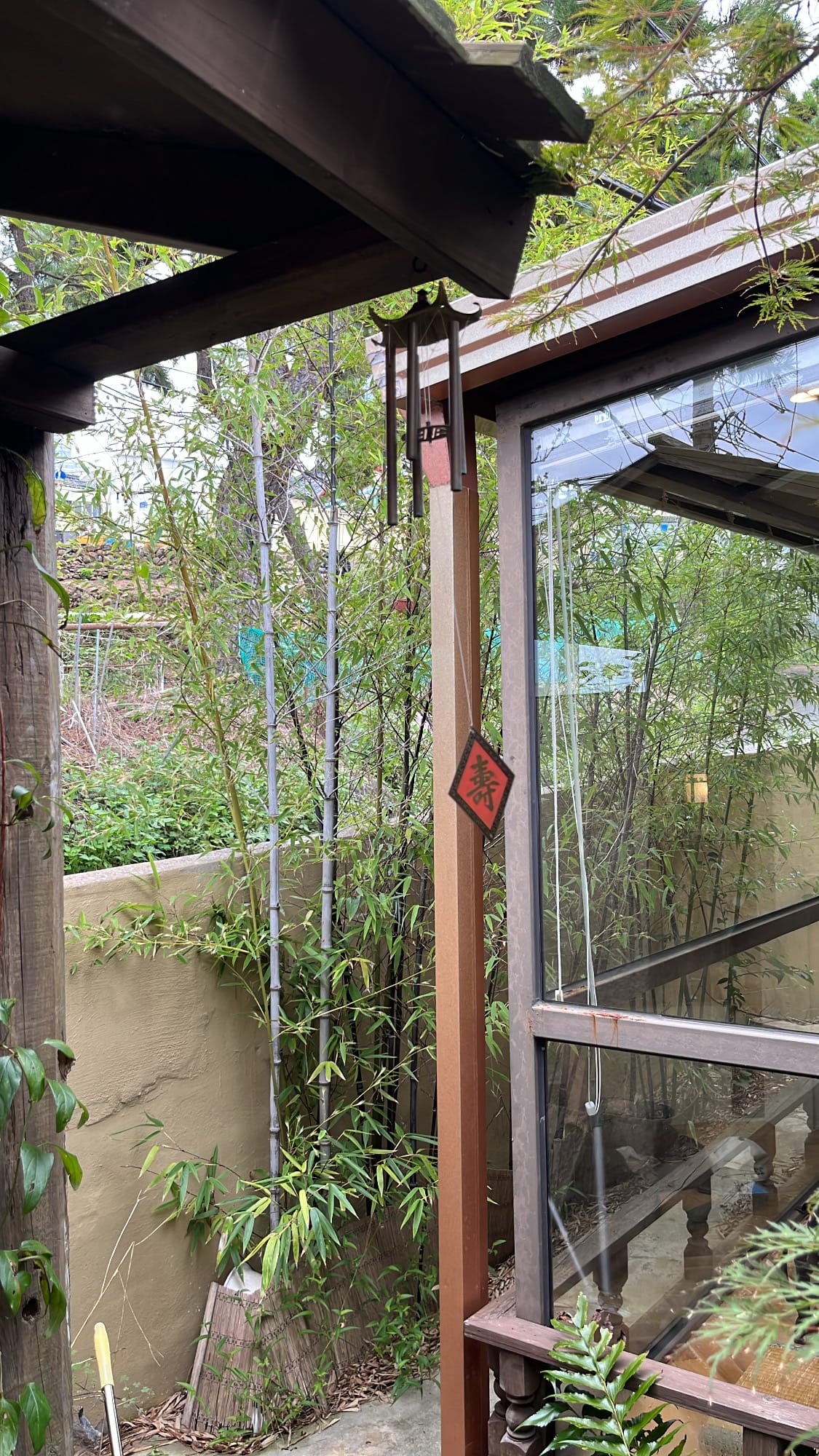 Wind chime swaying gently beside the outdoor bamboo garden at Simmian Busan