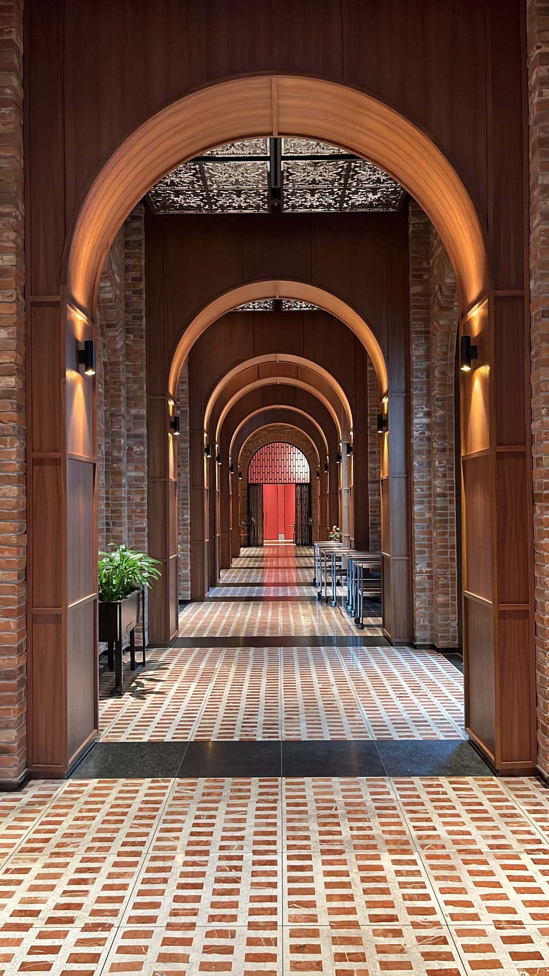 Elegant hallway with rhythmic brick arches and patterned floor tiles at Village de Ananti Lou Busan