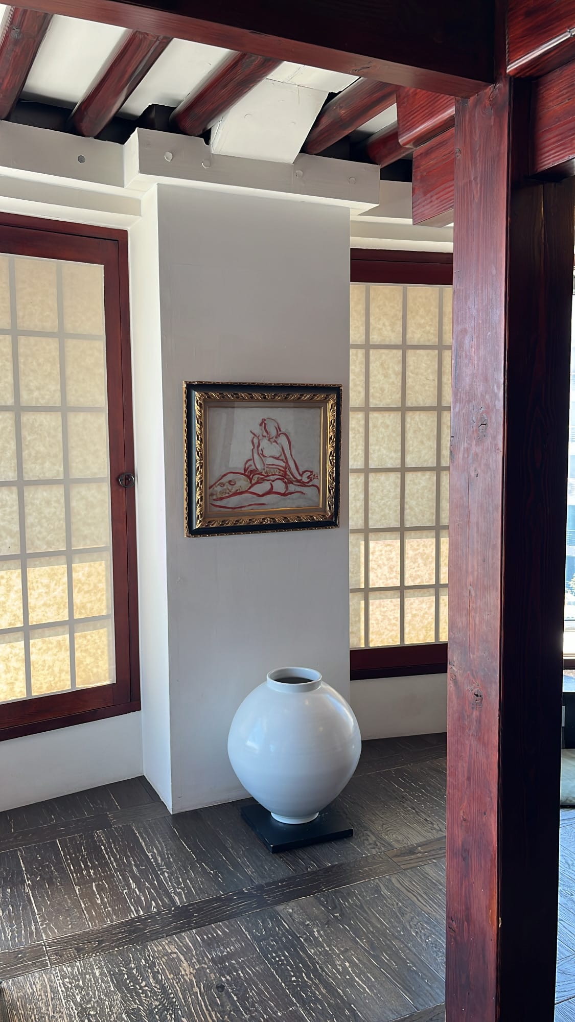 Traditional white ceramic jar and contemporary artwork displayed inside Bibibidang
