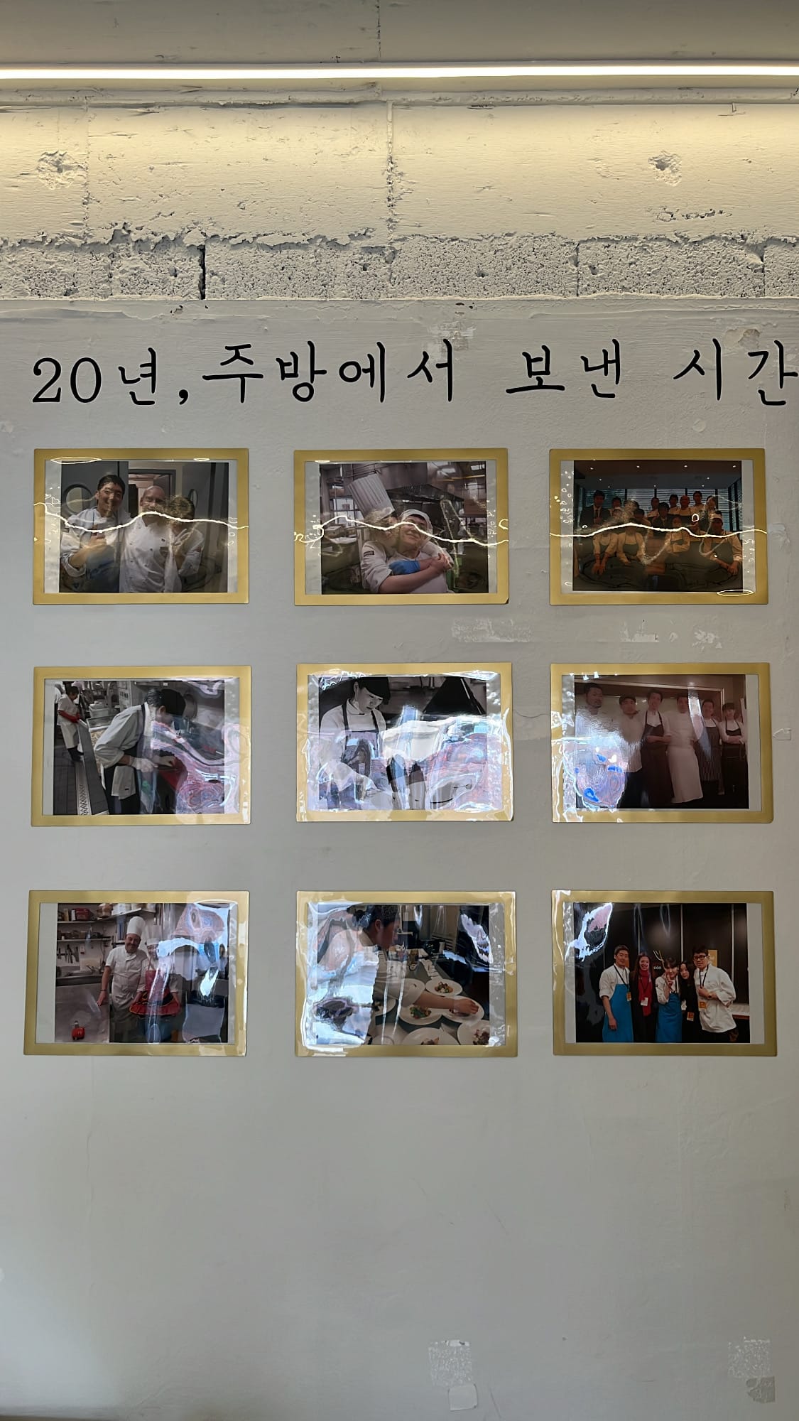 Photo wall showcasing the 20-year culinary career of Chef202 in Seoul fine dining