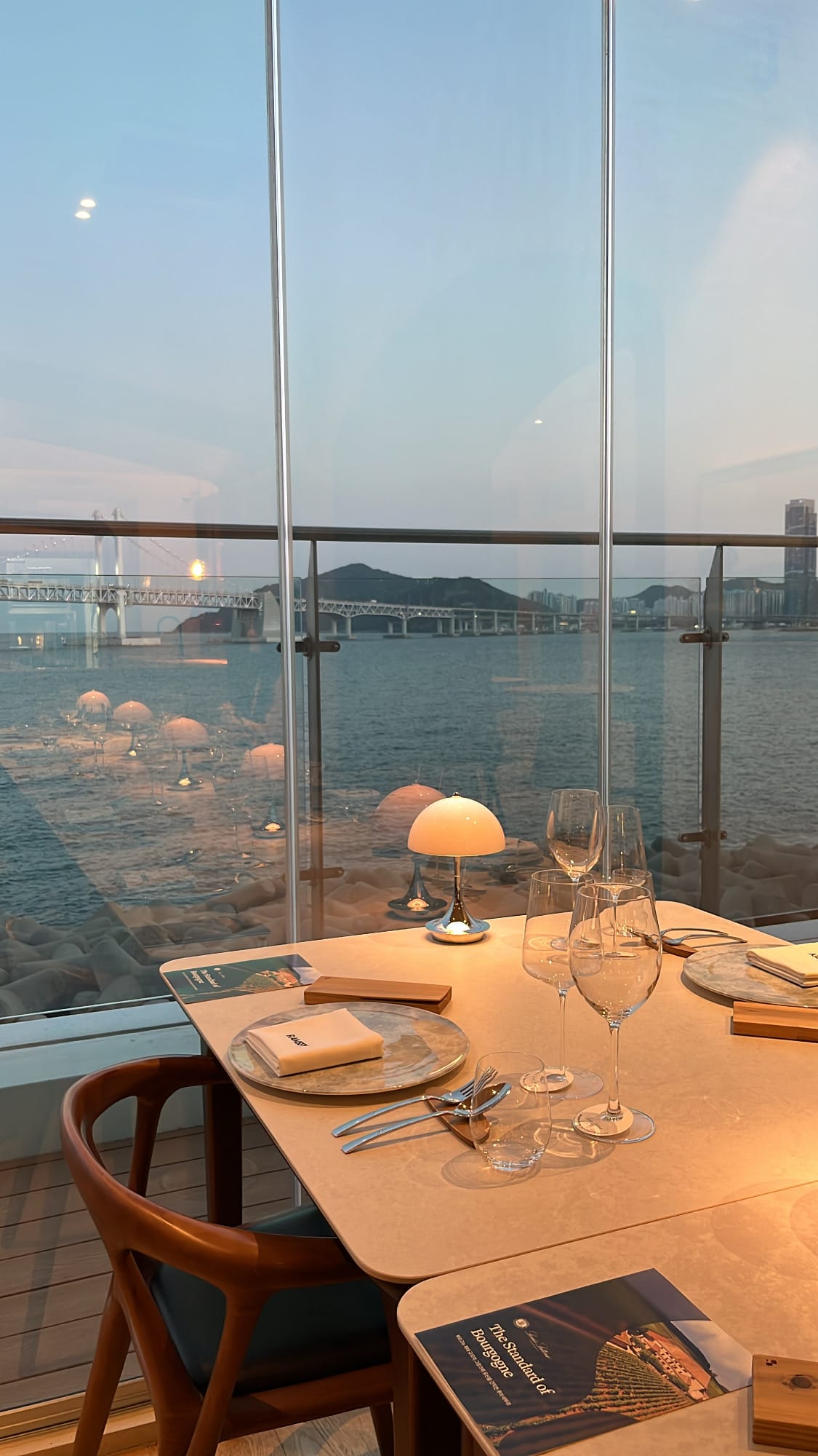 Dining table setup facing Gwangan Bridge at Ramsey Busan