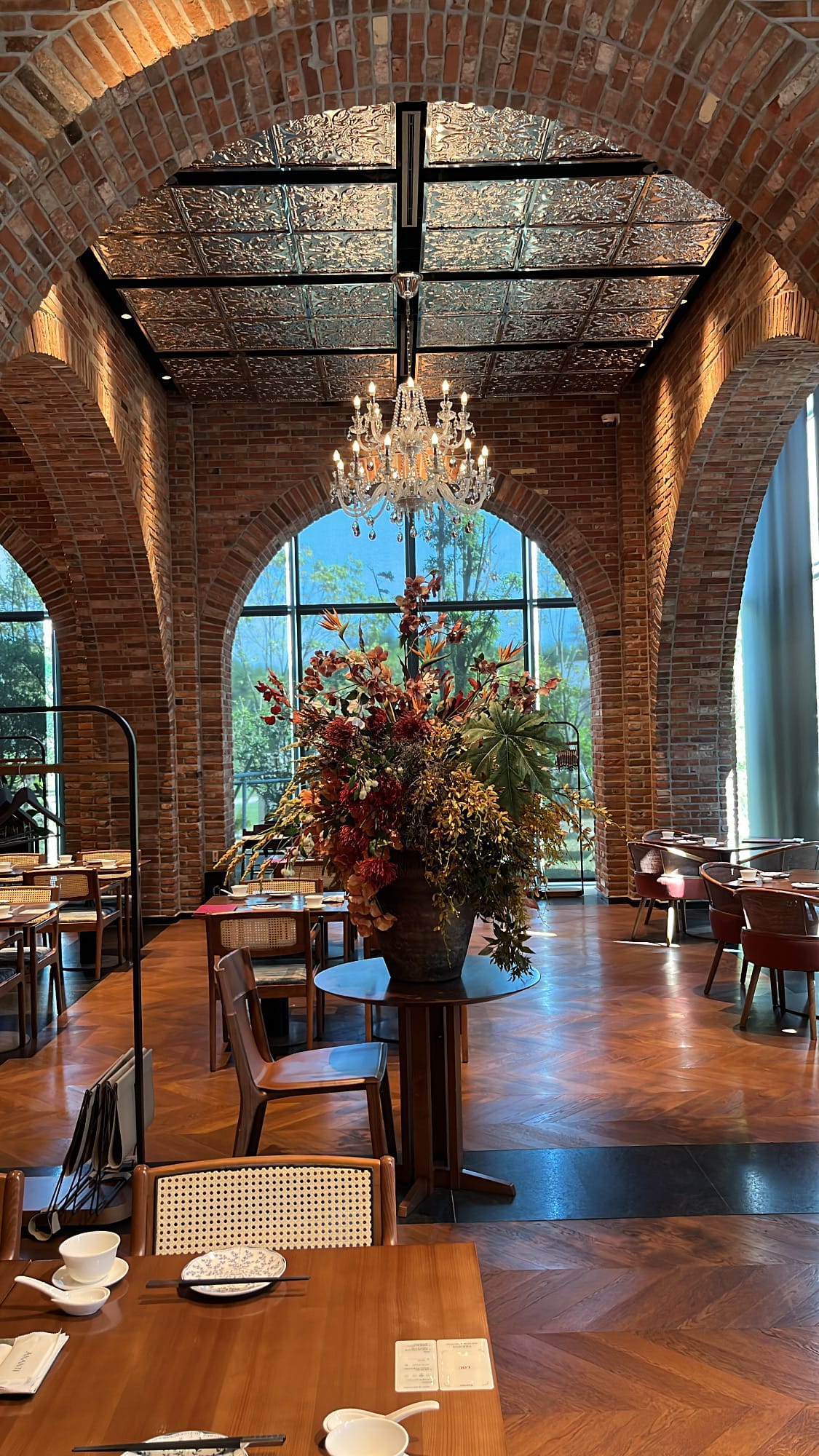 Expansive main dining hall featuring high arched windows and a large floral centerpiece at Village de Ananti Lou Busan