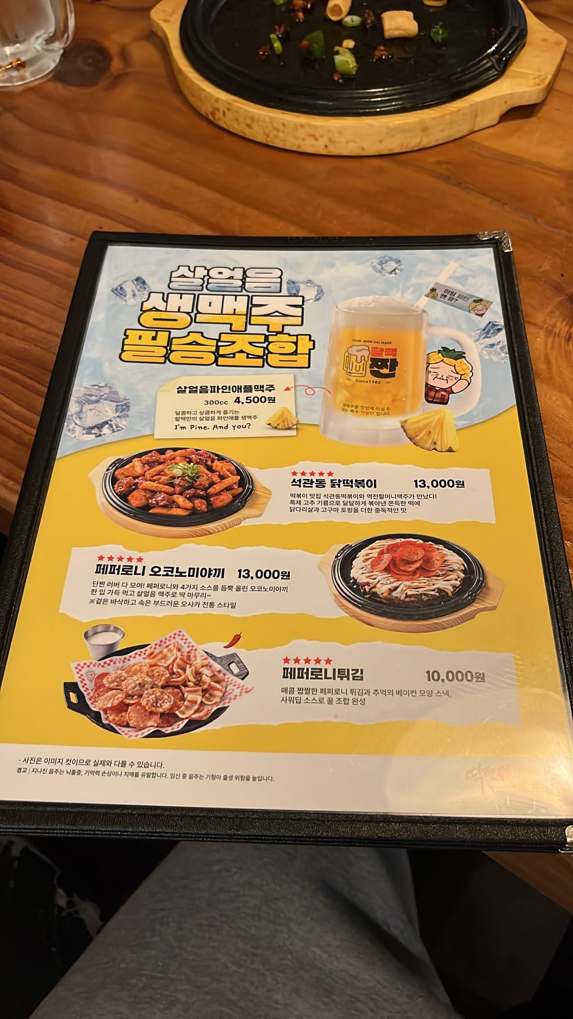 Printed seasonal menu featuring pineapple beer and spicy chicken tteokbokki