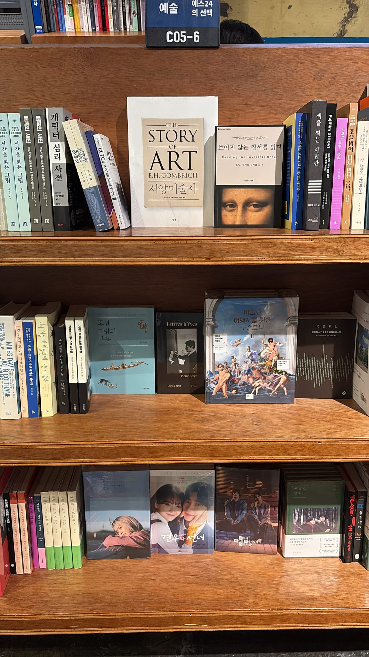 Curated art history book collection on wooden shelves at YES24 Busan