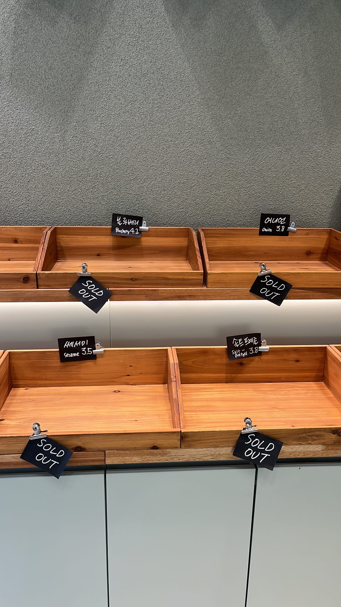 Wooden trays marked with sold-out tags showing high demand at Bagel Then You Busan Centum