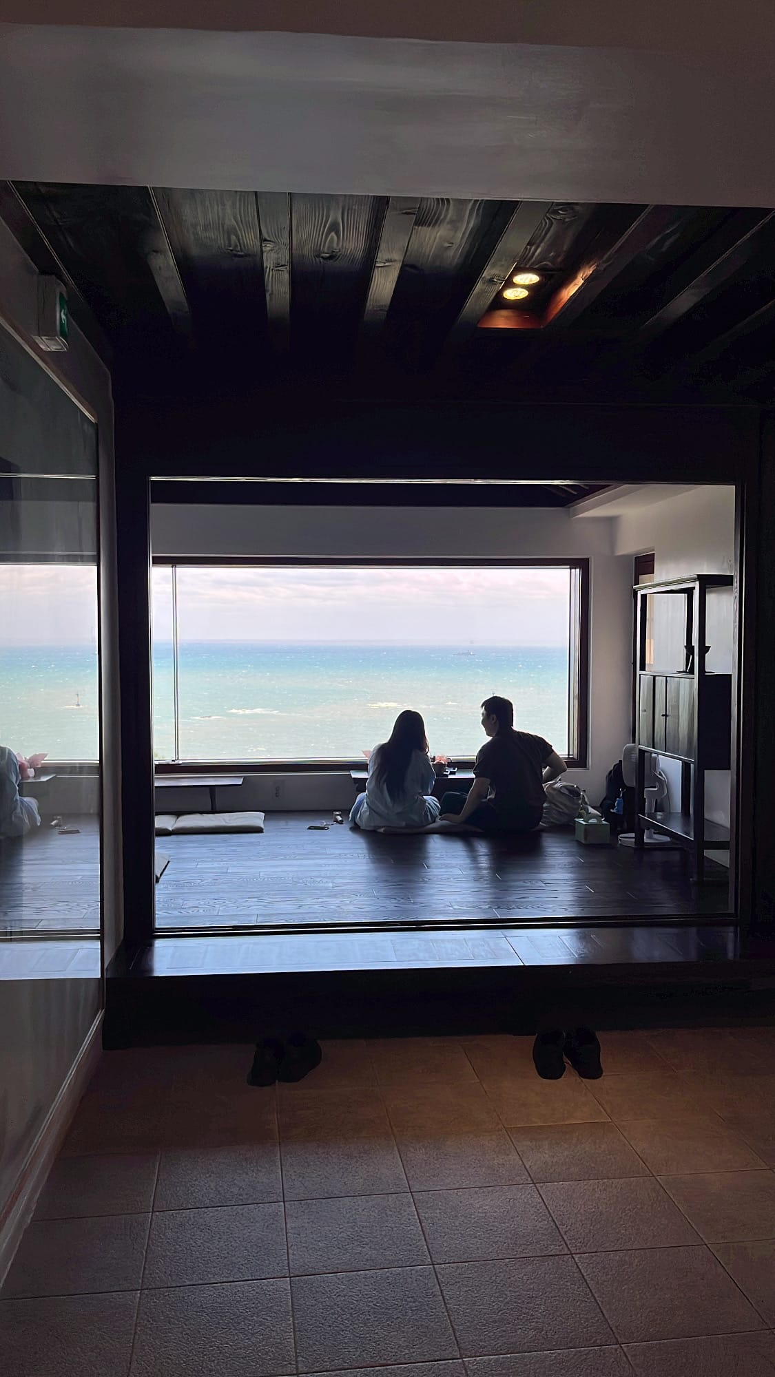 Private traditional seating room overlooking the ocean through a wide window