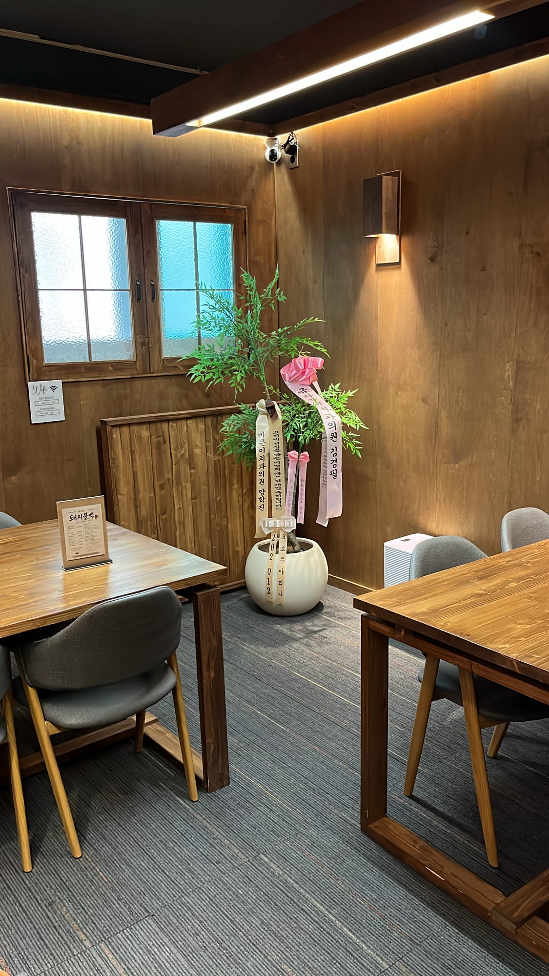 Cozy wood-paneled dining corner with potted plant at Chef202 Busan