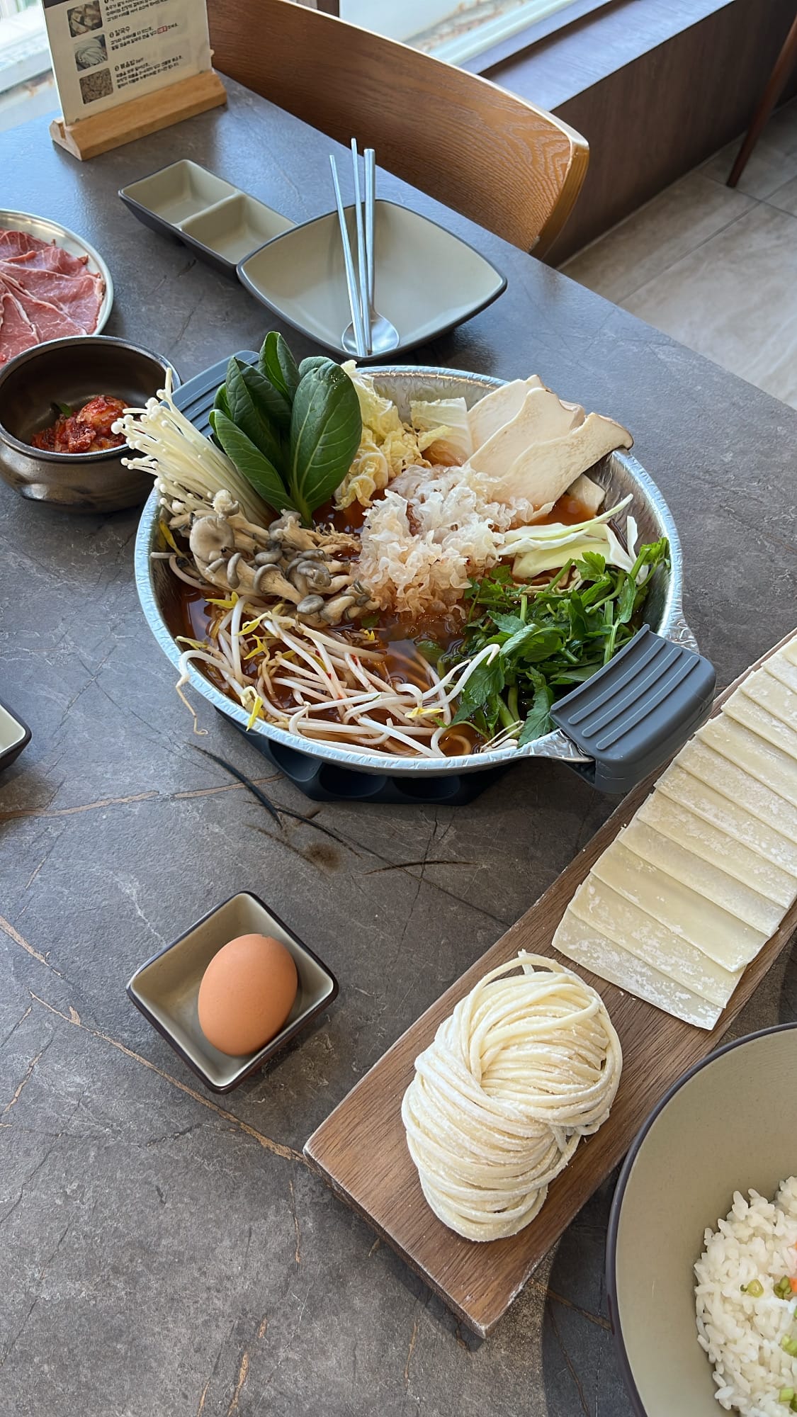 Full shabu-shabu course set including fresh vegetables, handmade noodles, and rice