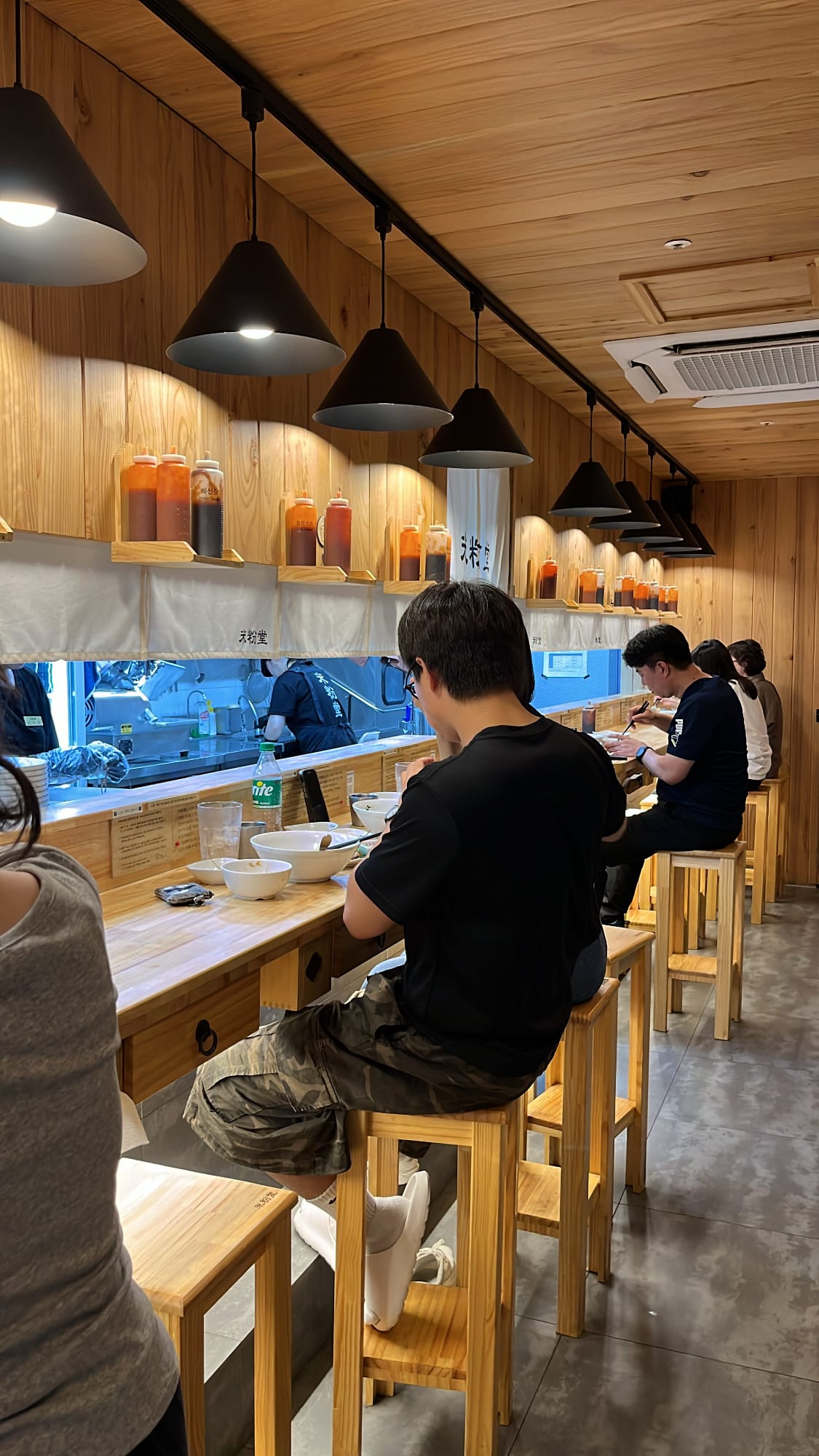Guests enjoying Vietnamese noodle dishes along the counter bar at Mibundang Centum City