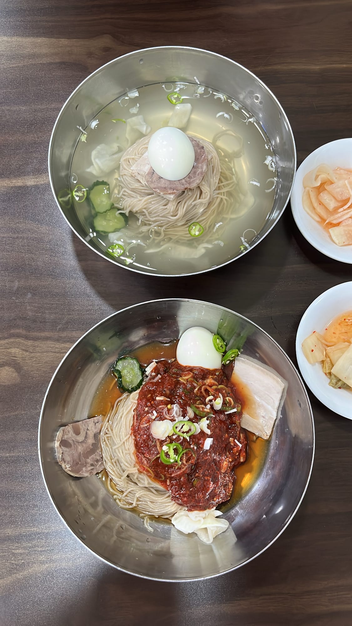 Overhead close-up of signature cold noodles with radish kimchi at 100.1.Pyeongnaeng Busan