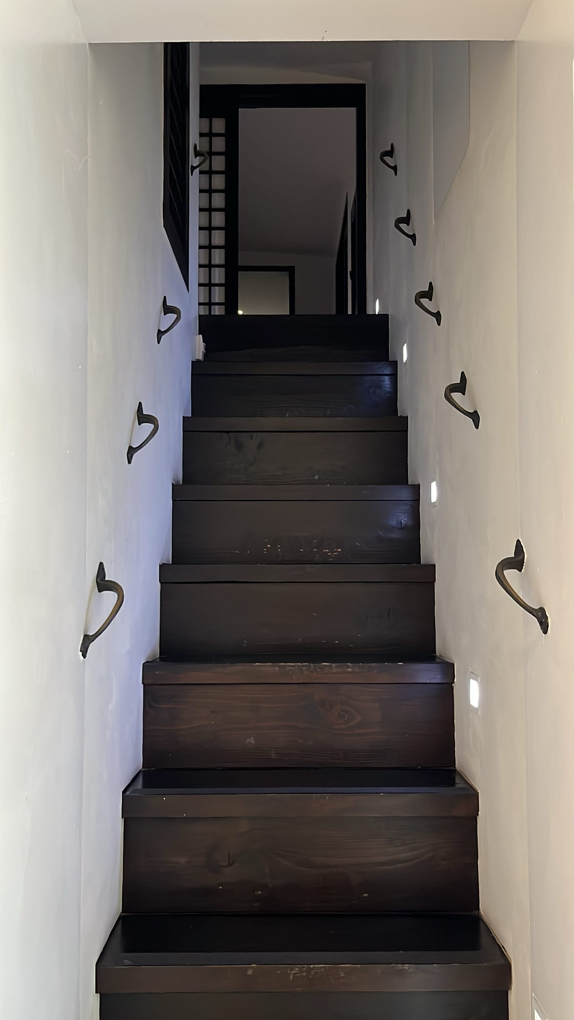 Dark wooden staircase leading to the second floor of Bibibidang
