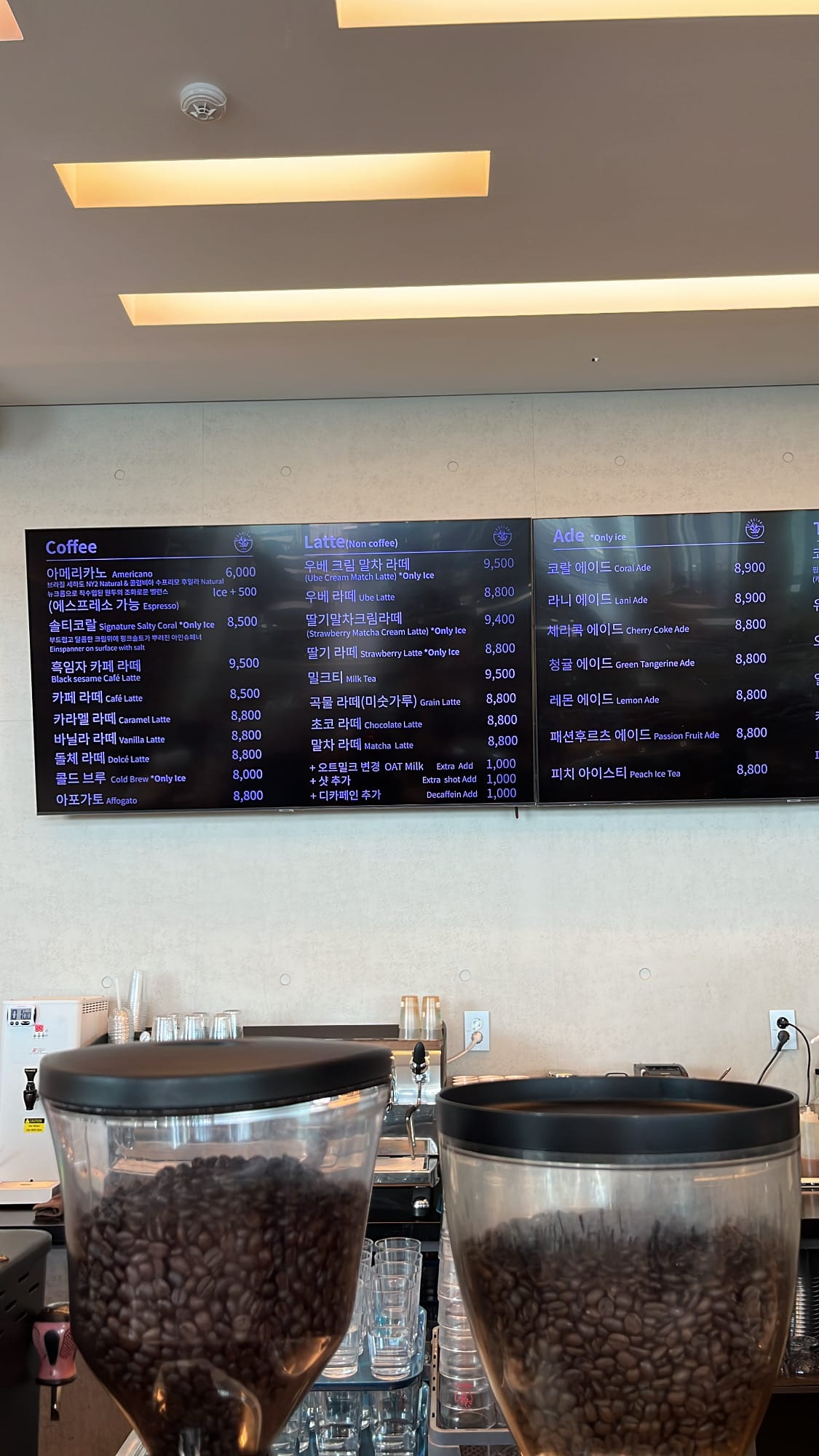 Digital drink menu board displaying coffee and specialty latte selections at Coralani Busan