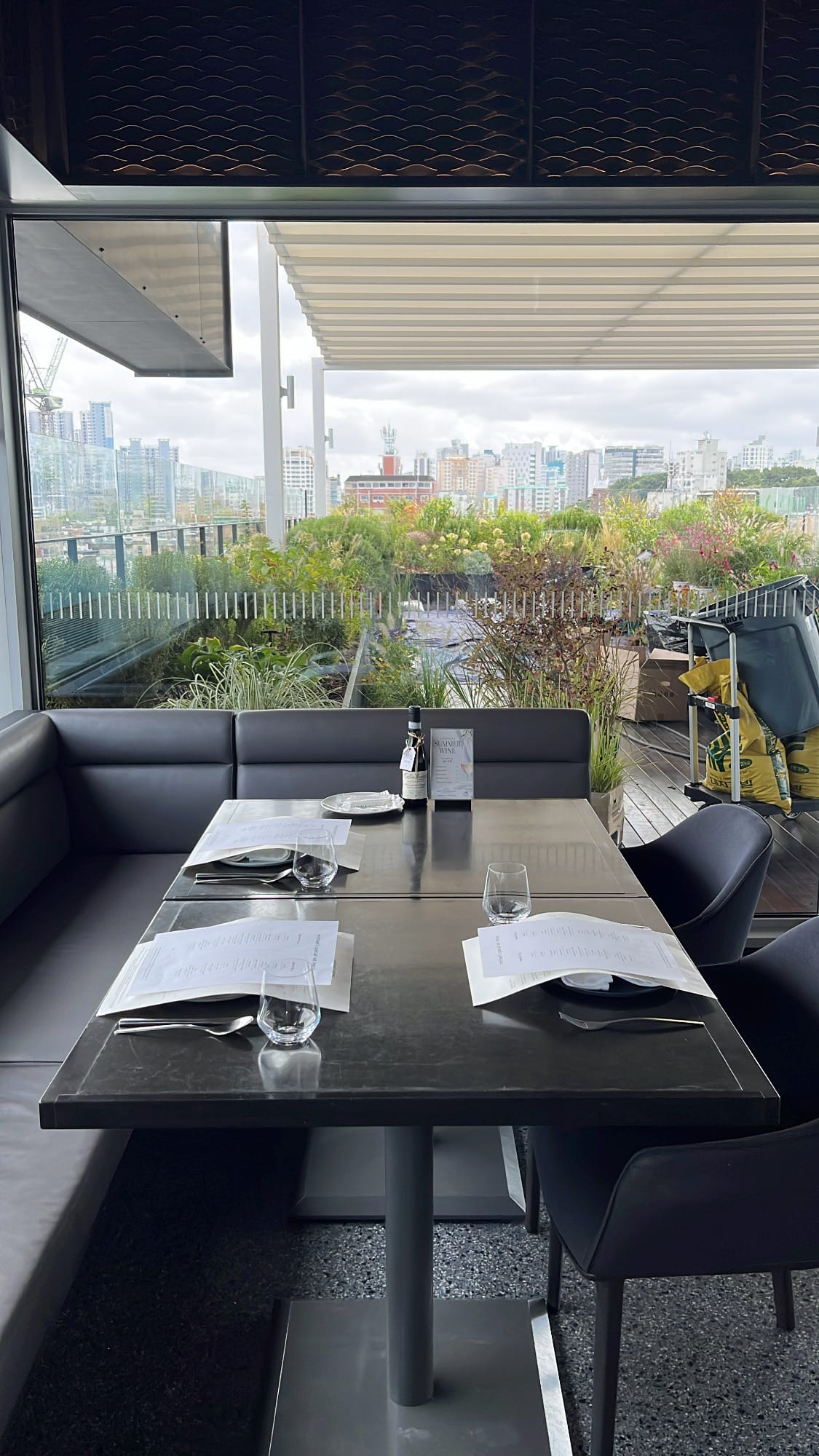 Cozy leather booth table overlooking outdoor terrace garden at Michael's Urban Farm Table