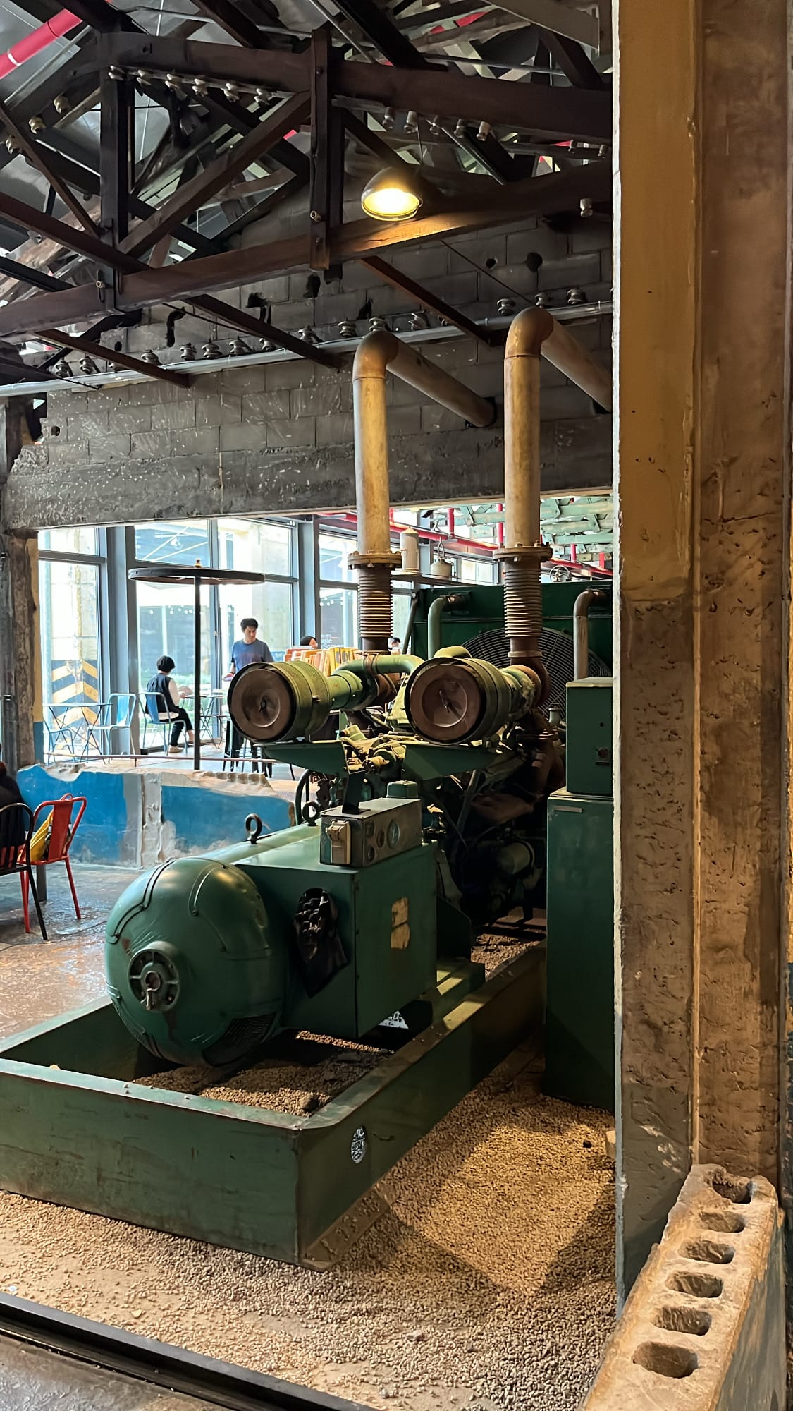 Heavy vintage factory generator engine preserved on gravel flooring